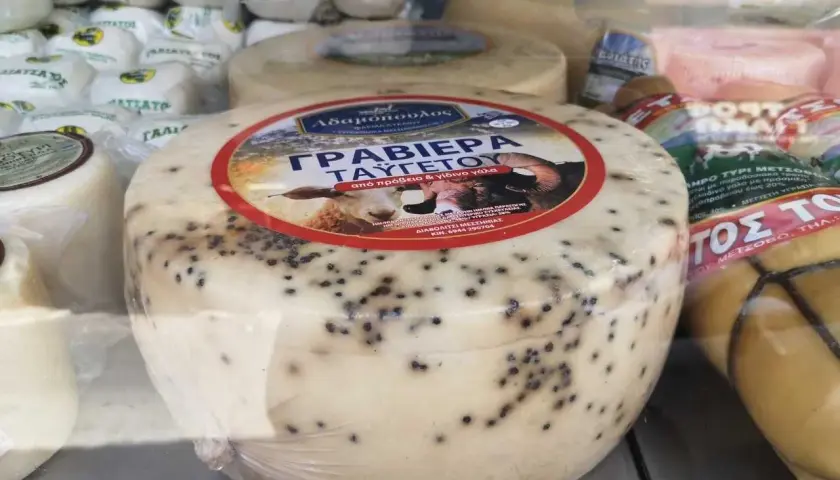 Formaggio rotondo con puntini neri, forse pepe, etichetta con pecora. Non è feta, ma una graviera greca.