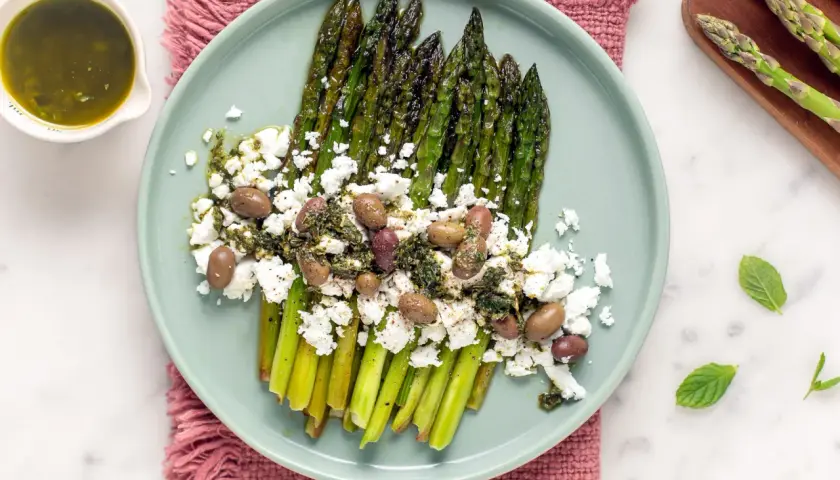 Asparagi grigliati con feta sbriciolata, olive e salsa verde. Un modo gustoso per condire la feta e creare un piatto fresco e saporito.