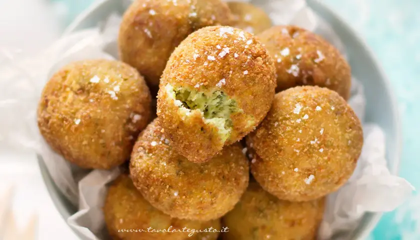 Deliziose polpette di zucchine e ricotta, dorate e croccanti, cosparse di sale grosso.