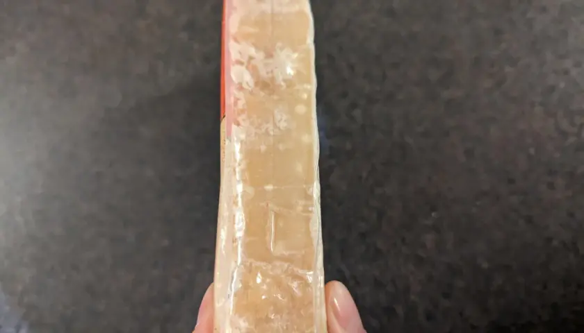 Un pezzo di formaggio stagionato, forse formaggio scaduto si può mangiare se non presenta muffe strane.