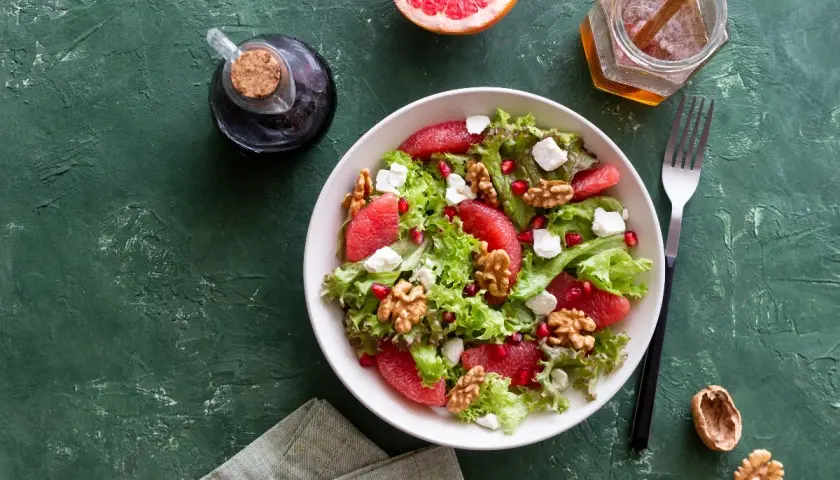 Insalata con pompelmo, noci e formaggi magri quali sono, condita con miele e aceto balsamico.
