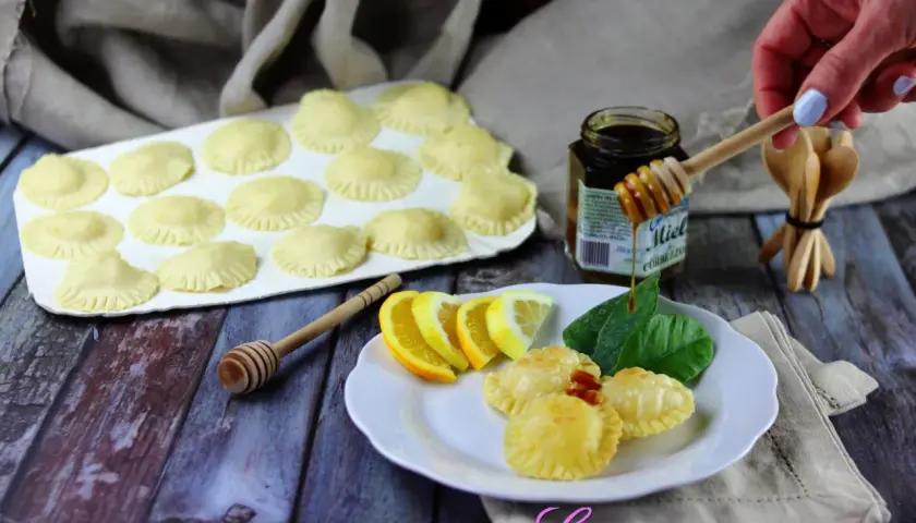 Seadas pronte per essere fritte, con miele, limone e arancia come ingredienti.