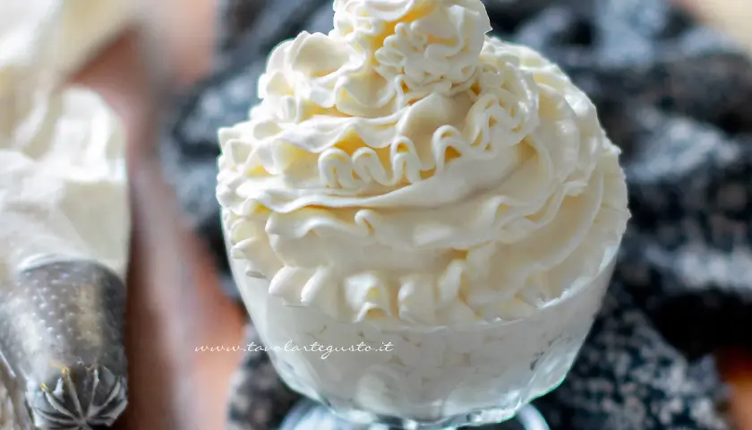 Coppa di golosa crema di latte, decorata con una sac à poche, pronta per essere gustata.