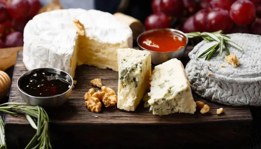 Assaggio di formaggi: un cremoso, un erborinato con venature blu e un formaggio grigio. Accompagnati da noci, miele e uva rossa.