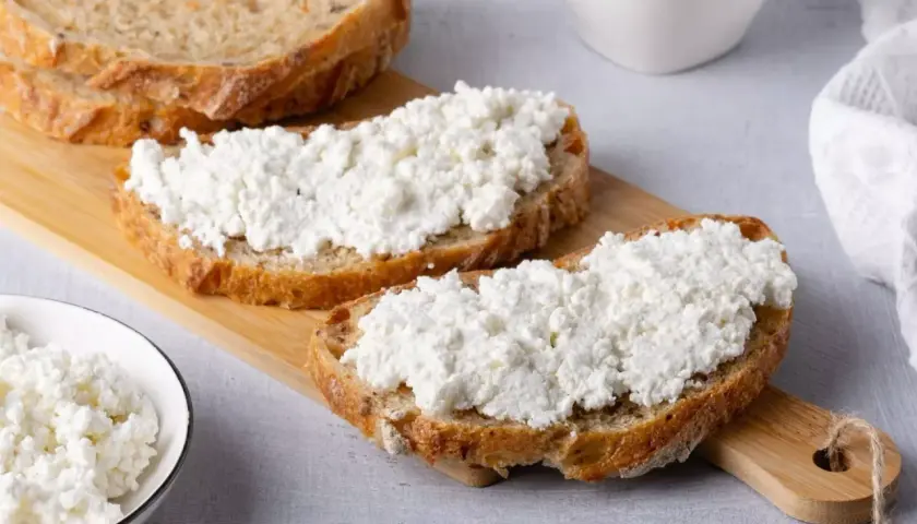 Fette di pane rustico con ricotta fresca, un'ottima scelta per scoprire i benefici della ricotta.