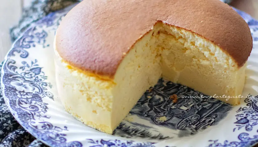 Un soffice cheesecake giapponese, leggero e arioso, servito su un piatto decorato con un motivo blu e bianco.