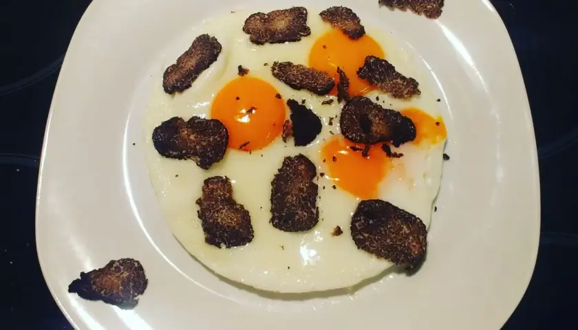 Uova al tartufo e formaggio, un piatto semplice ma raffinato. Le uova sono cotte alla perfezione, con tuorli morbidi e albumi bianchi e sodi. Il tartufo nero, tagliato a lamelle sottili, aggiunge un aroma intenso e un sapore inconfondibile. Il formaggi...