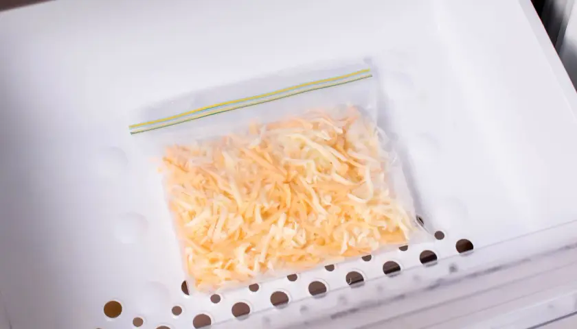 Sacchetto con formaggio grattugiato pronto per essere congelato. Si può congelare il formaggio grattugiato per averlo sempre a disposizione.