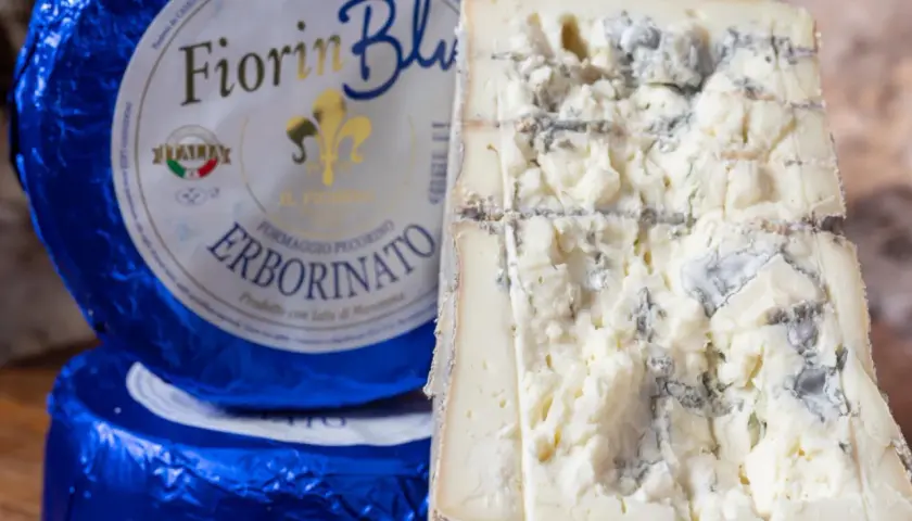 Fiorin Blu, un formaggio con muffa nome Erborinato, mostra venature blu e verdi su una pasta bianca e friabile.