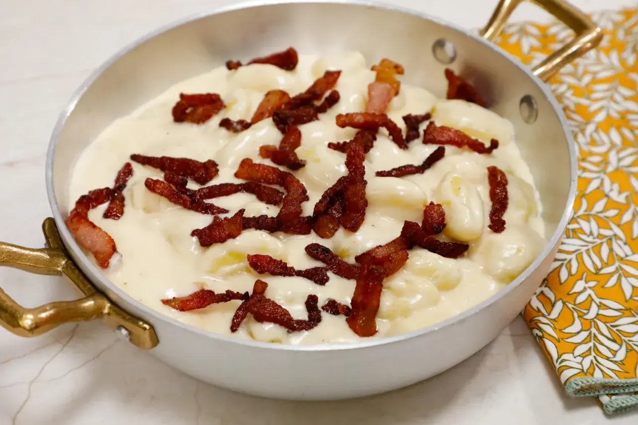 Gnocchi soffici in una cremosa fonduta, guarniti con croccante pancetta. Un piatto che invita alla gola.