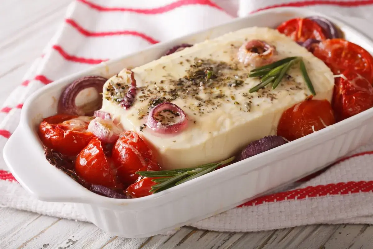 Piatto da forno con formaggio feta greca, pomodorini, cipolla rossa e rosmarino.