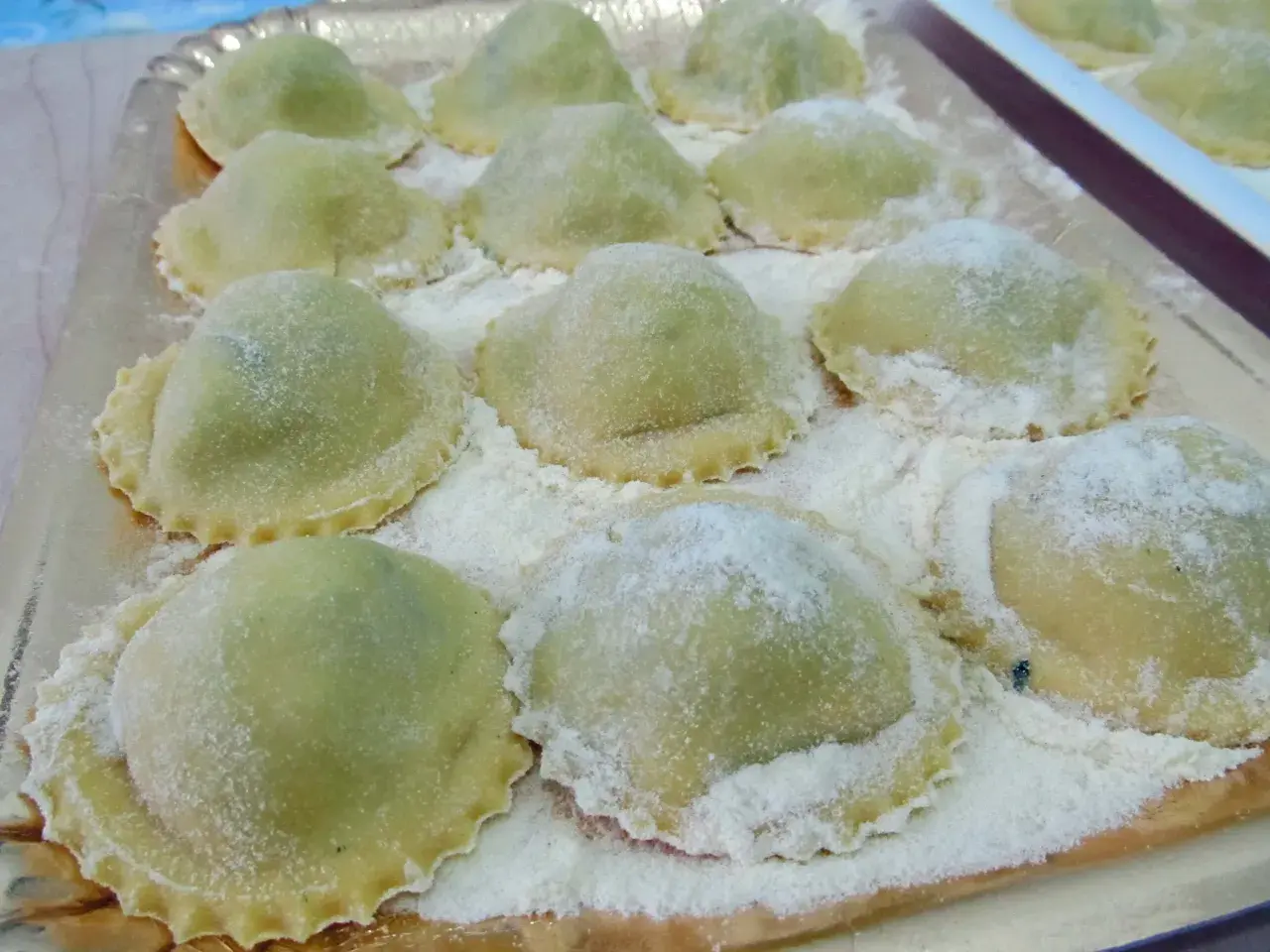 Ravioli verdi su vassoio, perfetti con cosa sostituire la ricotta nella dieta.