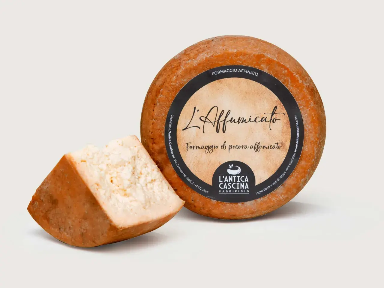 Formaggio di pecora affumicato, con una fetta tagliata. L'etichetta riporta "L'Affumicato" e "Formaggio di pecora affumicato".
