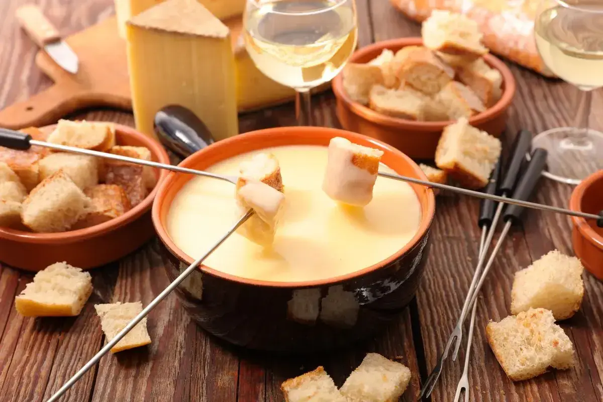 Fonduta cremosa con pane croccante e formaggio svizzero. Gli ingredienti perfetti per una serata conviviale.