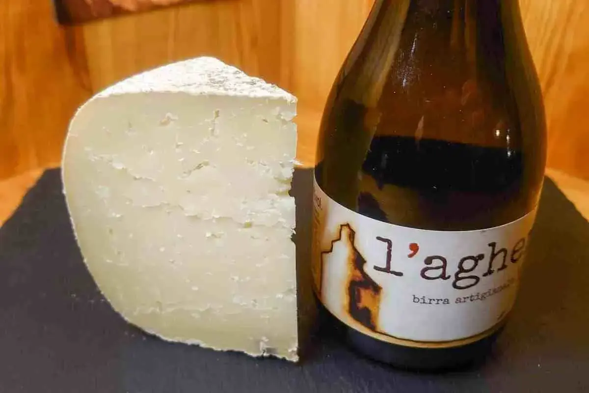 Un pezzo di formaggio stagionato accanto a una bottiglia di birra artigianale. Attenzione, il tomino fa ingrassare!