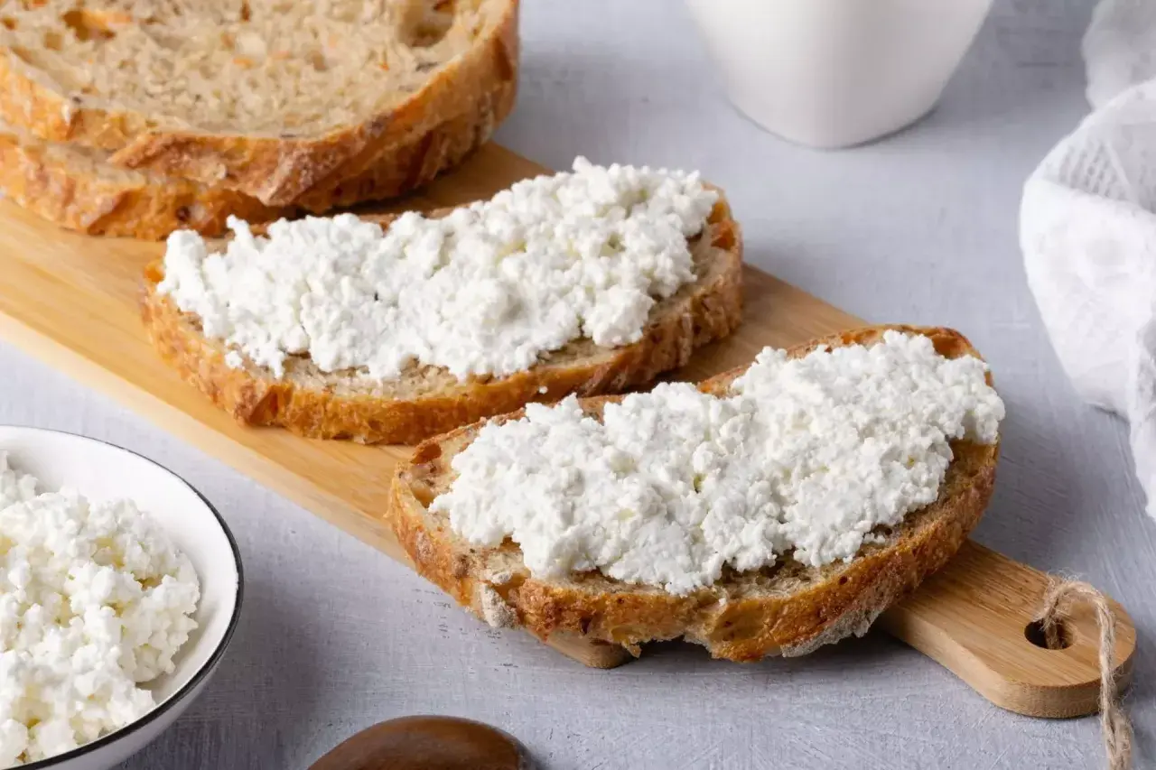 Fette di pane rustico con ricotta fresca, un'ottima scelta per scoprire i benefici della ricotta.