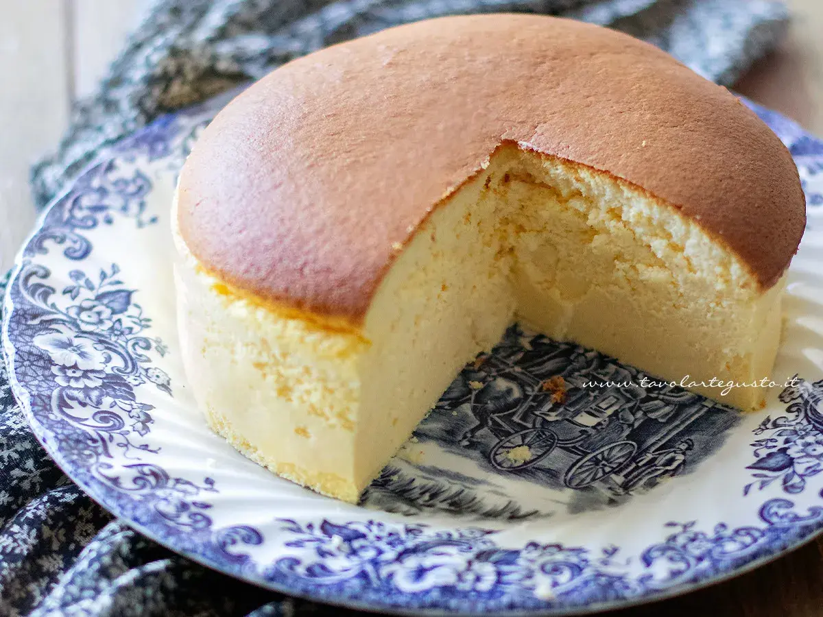 Un soffice cheesecake giapponese, leggero e arioso, servito su un piatto decorato con un motivo blu e bianco.