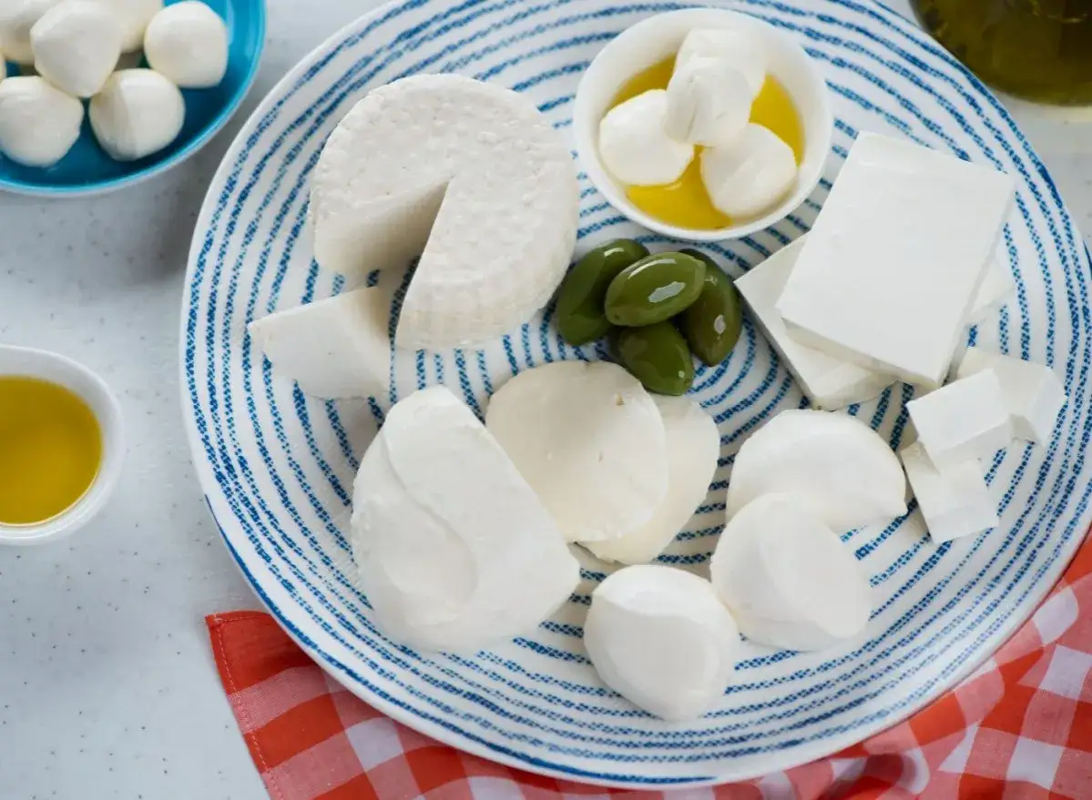 Assortimento di formaggi freschi, tra cui mozzarelline e feta, perfetti per chi cerca un formaggio spalmabile con attenzione al colesterolo.