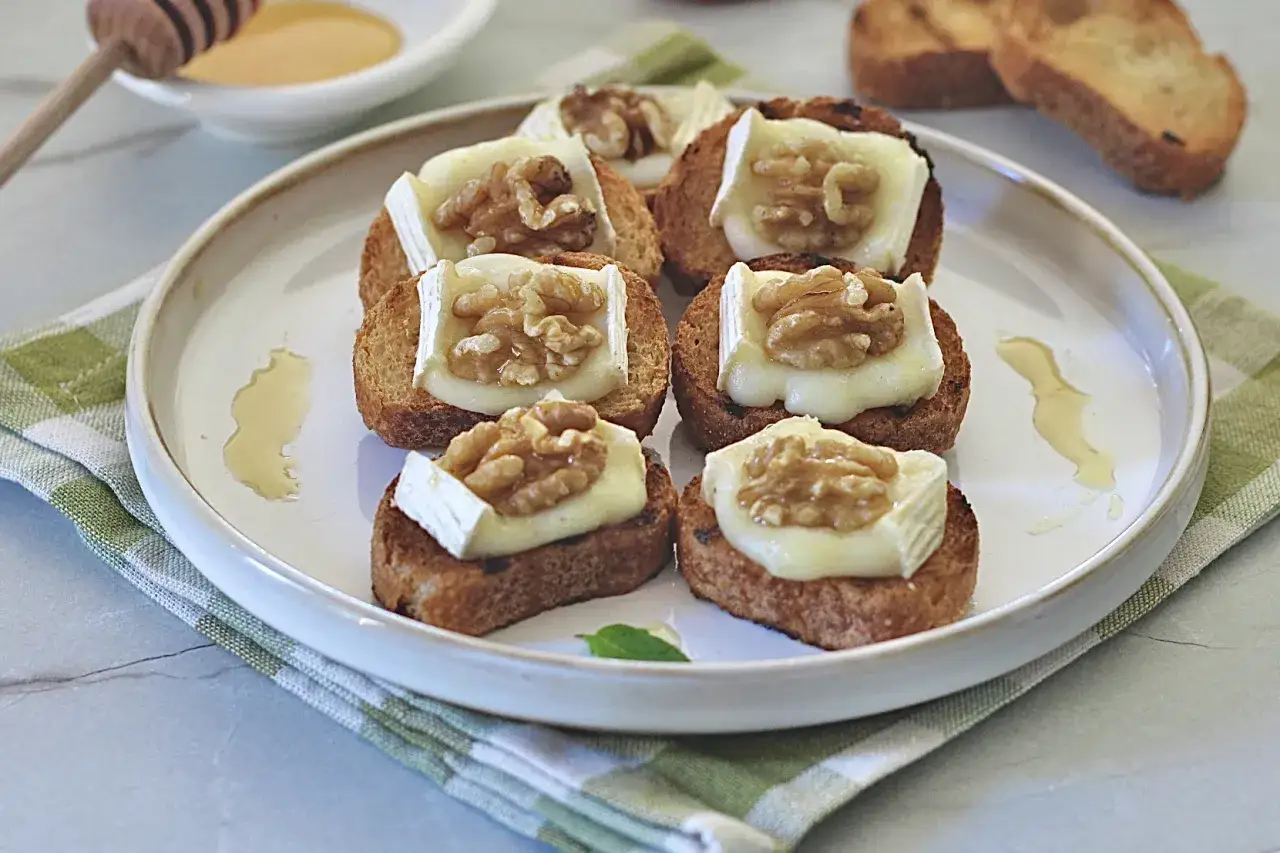 Deliziosi crostini con formaggio fuso e noci, un antipasto perfetto per ogni occasione.