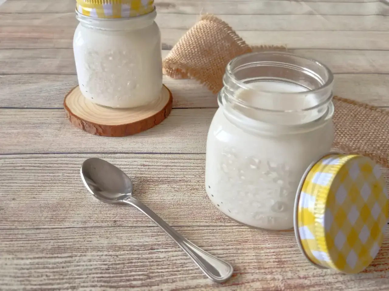 Due vasetti di vetro con yogurt fatto in casa, pronti per essere gustati. Ecco come si fa lo yogurt!