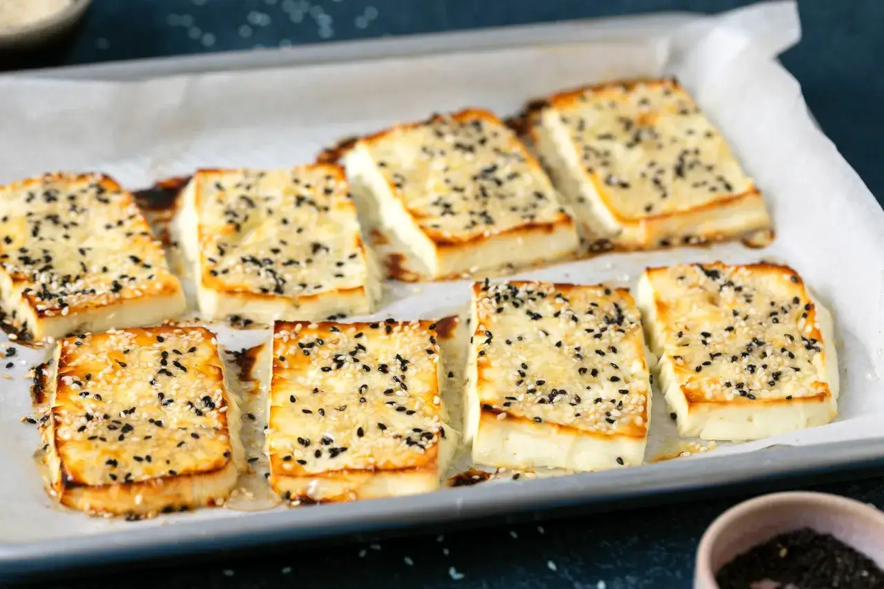 Fetta dorata e croccante, cosparsa di semi di sesamo bianchi e neri. Un modo delizioso per scoprire come condire la feta.