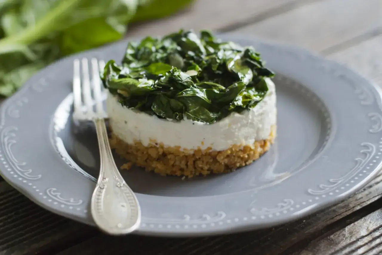 Cheesecake salata con taralli sbriciolati, crema bianca e spinaci freschi.