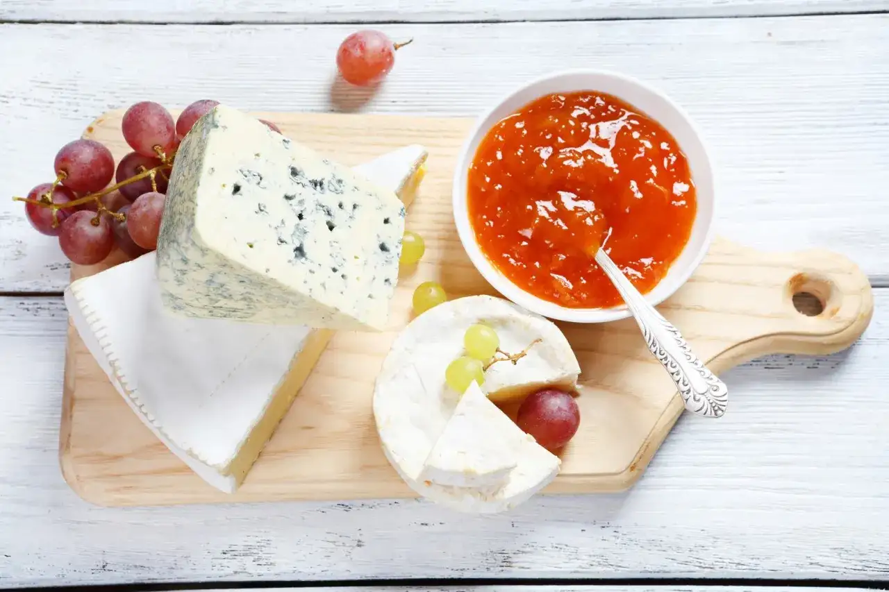 Selezione di formaggi: Gorgonzola, Brie e un altro non identificato, con uva e marmellata. Meglio formaggio di capra o pecora? Difficile scegliere!