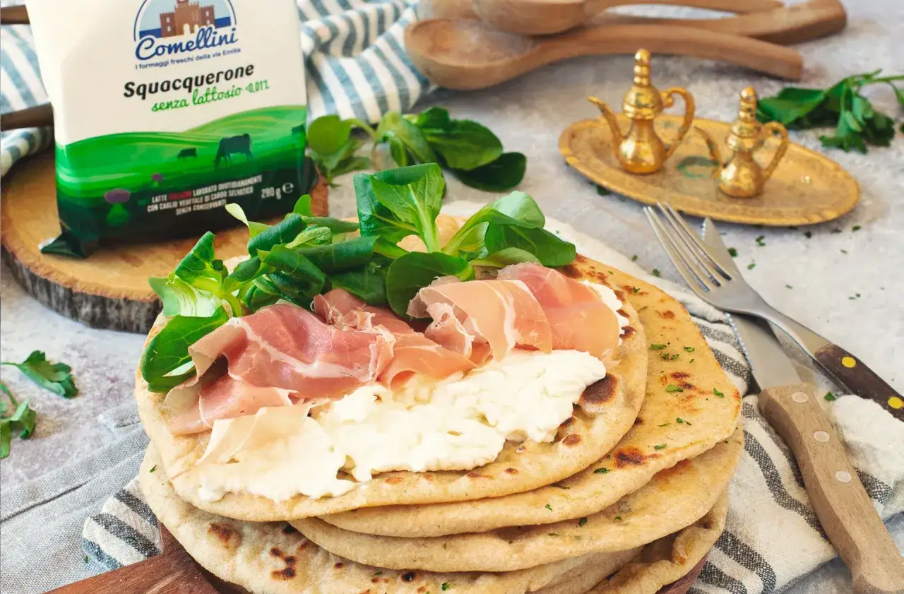 Piadina con squacquerone, prosciutto crudo e insalatina. Un classico degli abbinamenti perfetti per un pasto veloce e gustoso.
