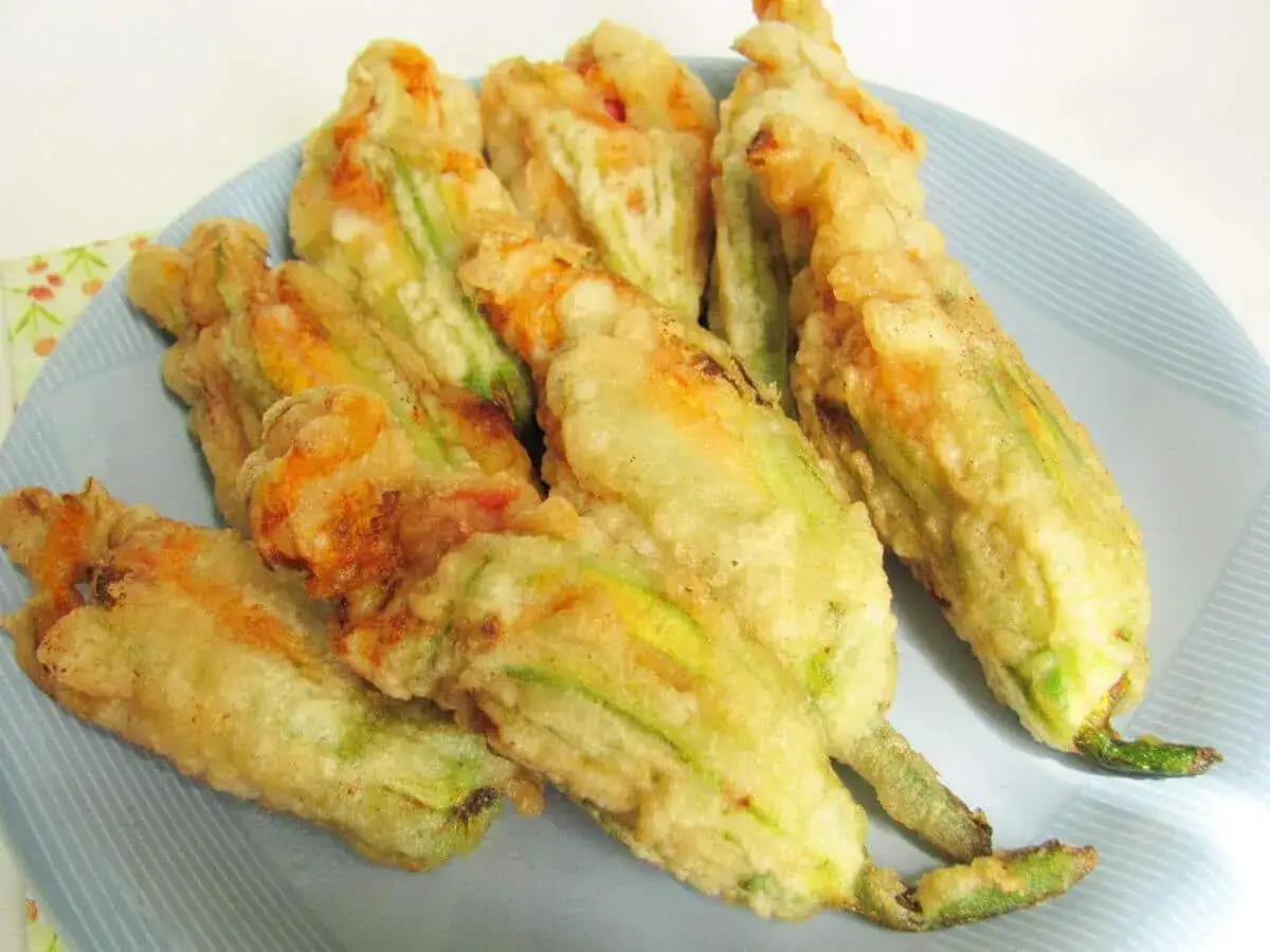 Fiori di zucca ripieni di ricotta, dorati e croccanti, pronti per essere gustati.