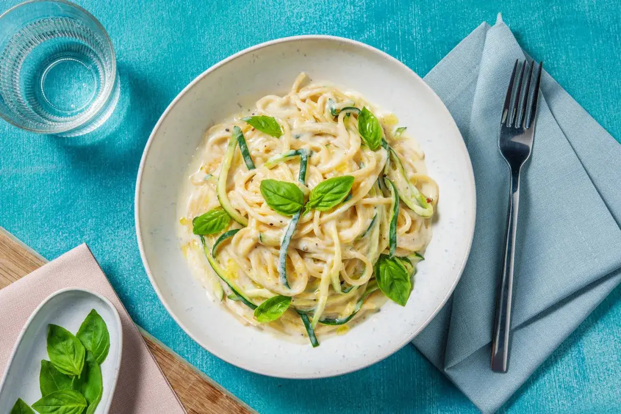 Spaghetti cremosi con zucchine e basilico, avvolti in una deliziosa fonduta di pecorino.