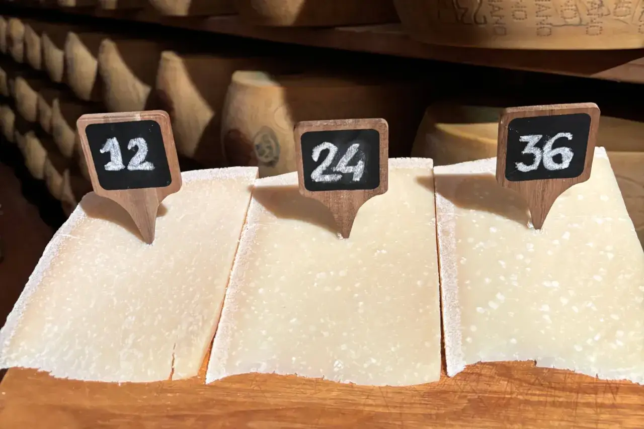 Fette di formaggio con cartellini numerati 12, 24, 36. Attenzione: il parmigiano contiene lattosio.