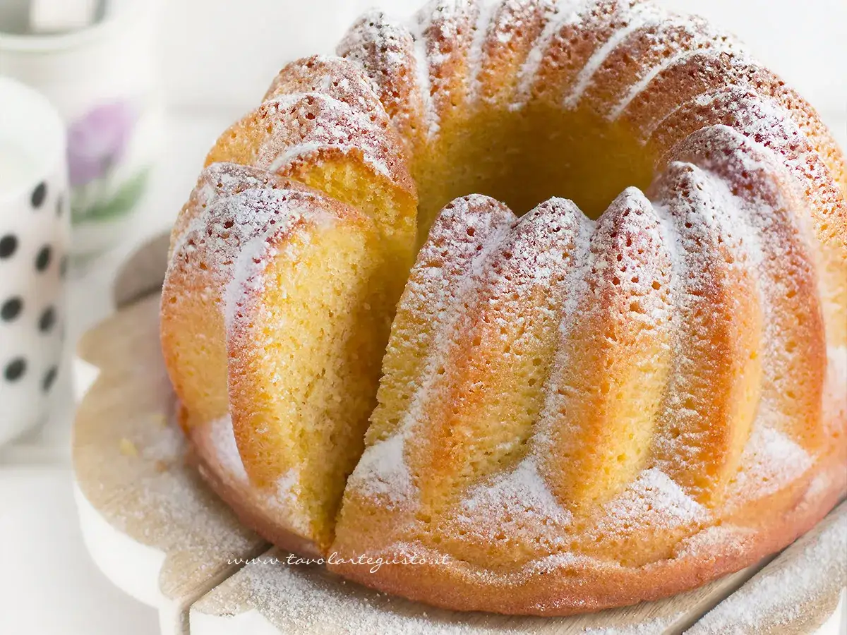 Un soffice ciambellone allo yogurt, cosparso di zucchero a velo, pronto per essere gustato.