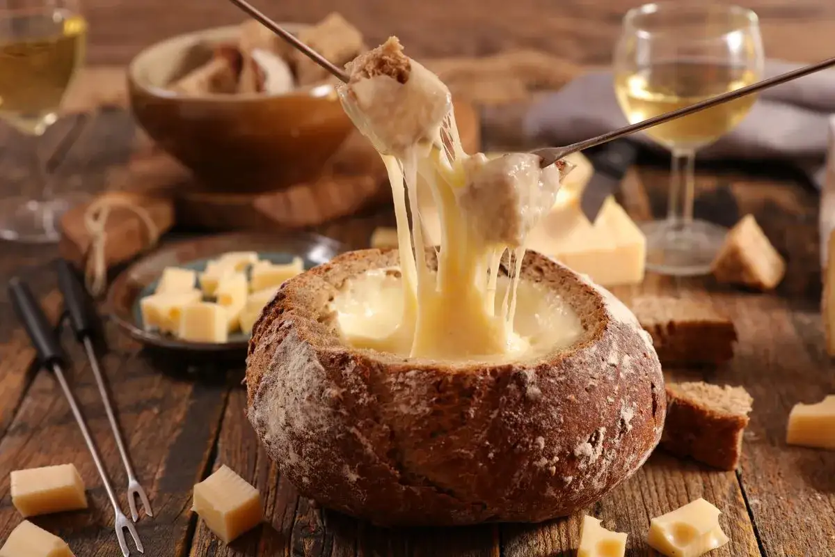 Fonduta di formaggio fatto in casa da Benedetta, filante e invitante, servita in una pagnotta scavata. Perfetta per una serata conviviale.