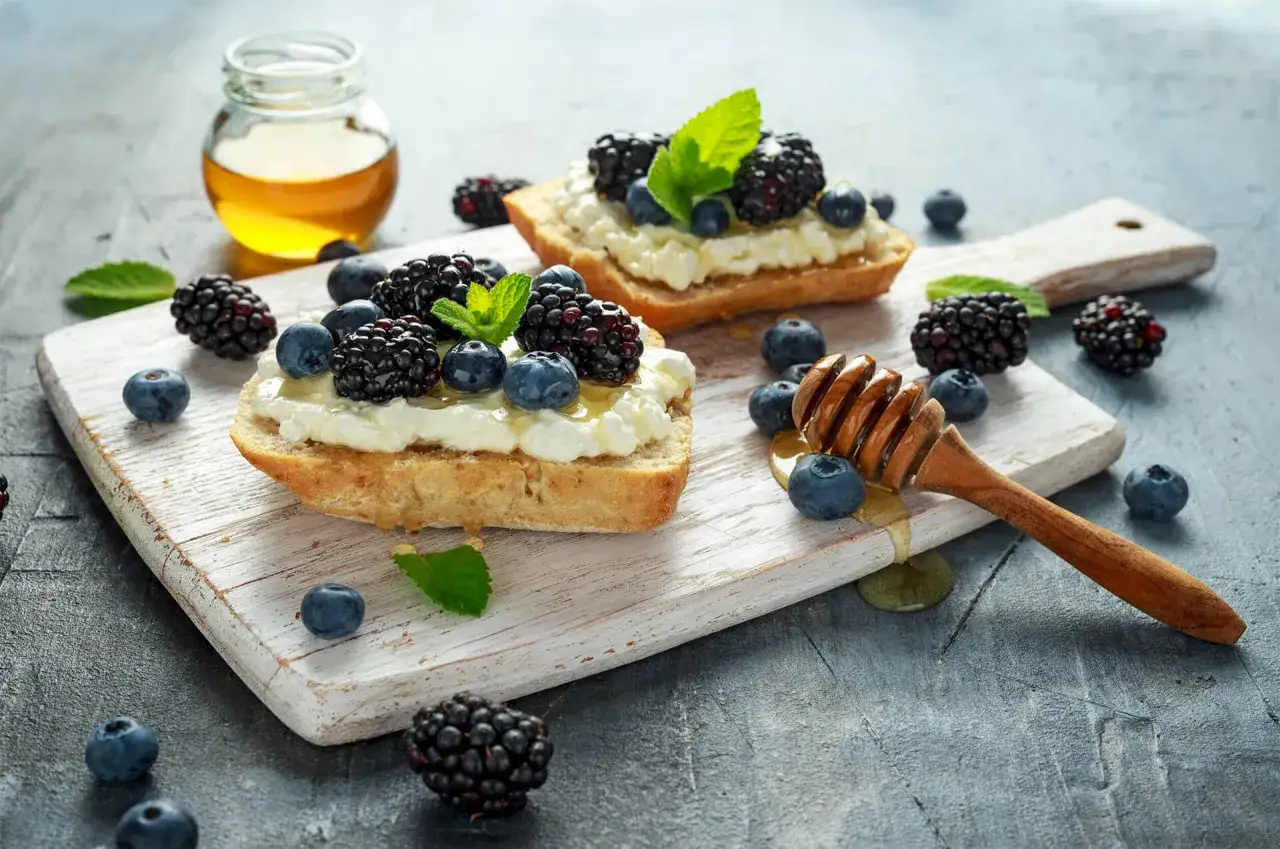 Bruschette con ricotta, frutti di bosco e miele, un'idea sana per la ricotta a colazione nutrizionista.