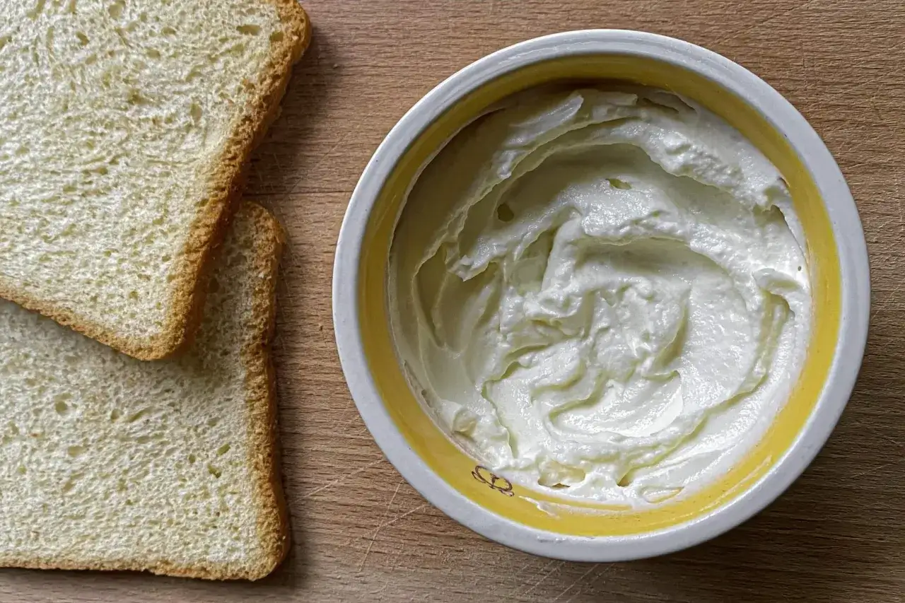 Fette biscottate e una ciotola con formaggio cremoso, pronto per una semplice ricetta di formaggio fuso.
