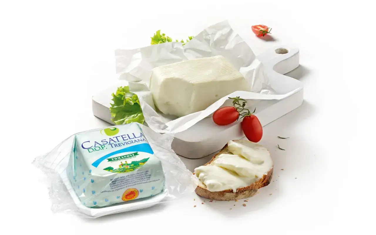 Formaggio fresco spalmabile, ideale per capire la differenza tra stracchino e crescenza. Servito su pane con pomodorini.