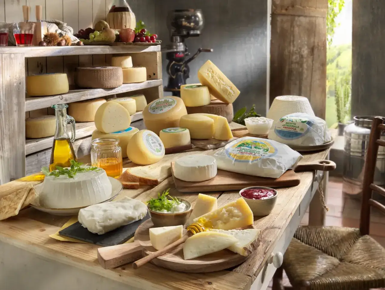 Un ricco assortimento di formaggi a pasta cruda, freschi e stagionati, con miele, marmellata e olio d'oliva, su un tavolo di legno rustico.